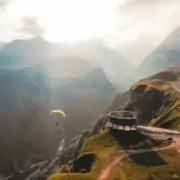 person paragliding on mountain cliff during daytime